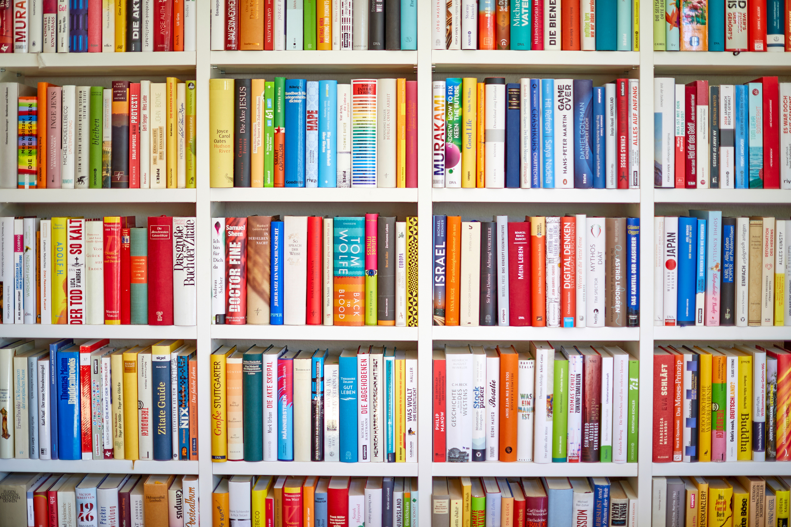 White library shelf with multi colored books